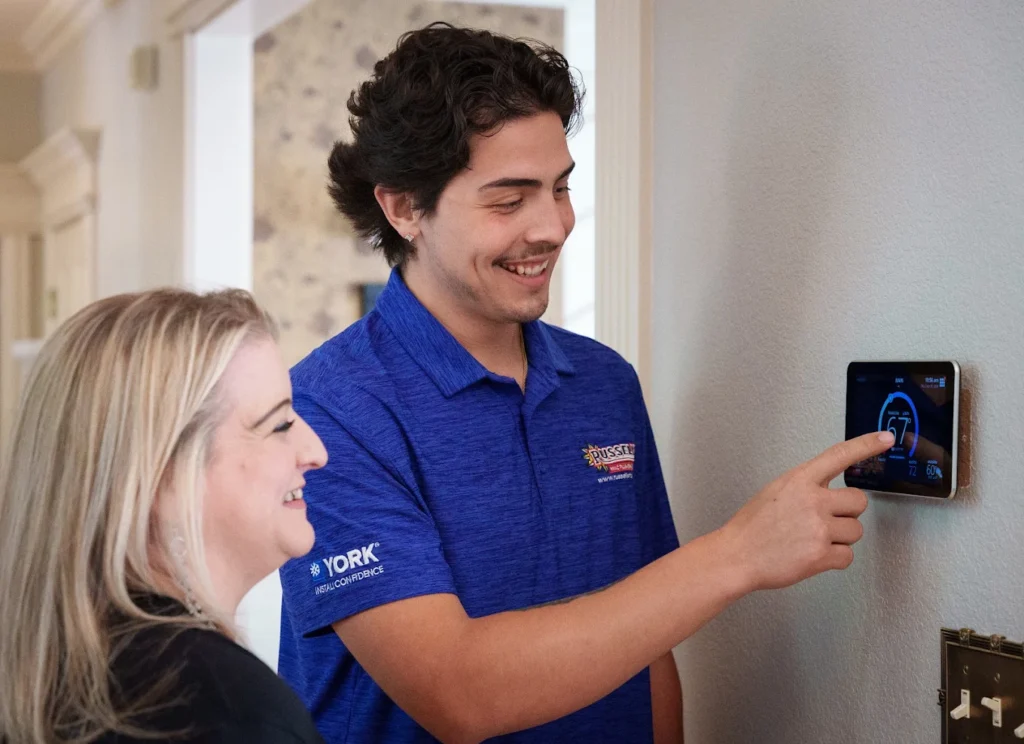 Russell's technician demonstrating use of a smart thermostat